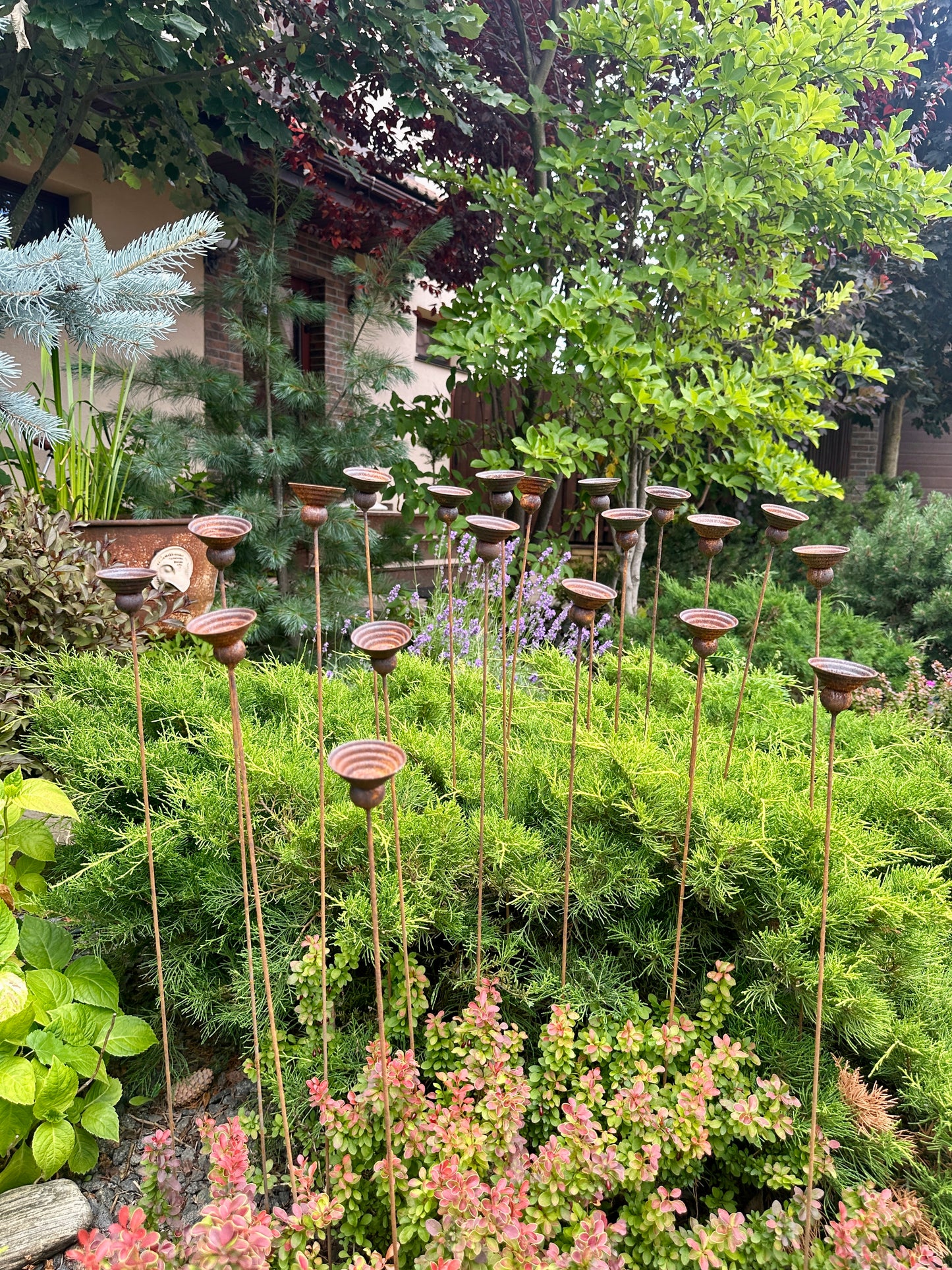 Decorative metals in a garden setting with trees and plants in the background