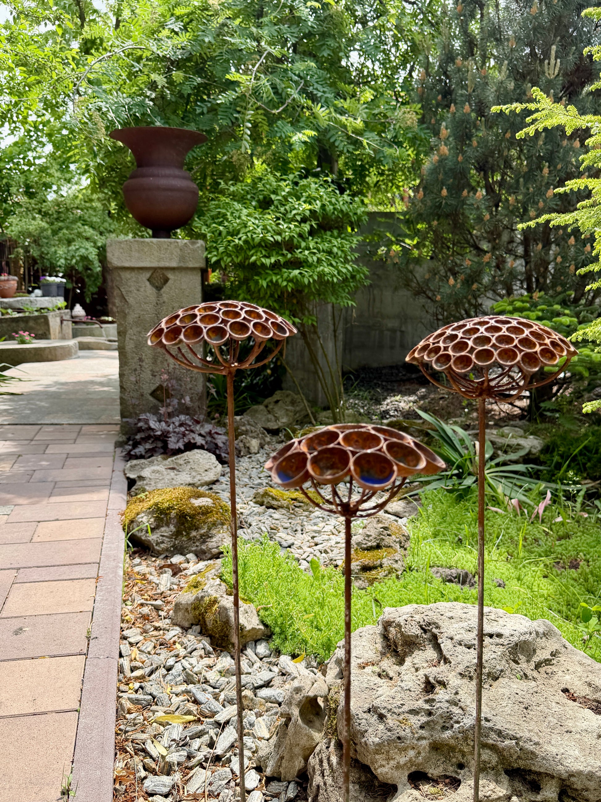 Garden scene with decorative metal sculptures and natural elements