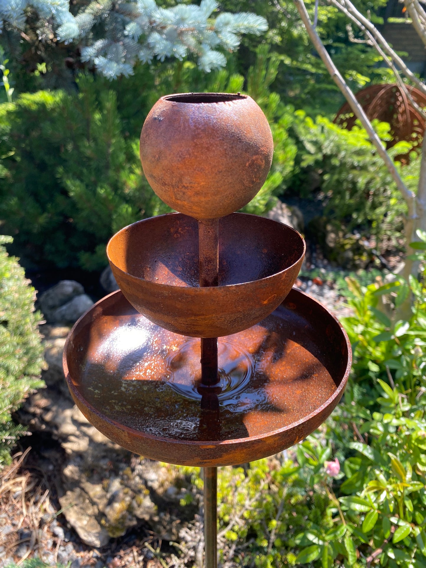 Rusty metal rain catchers bird baths bird feeder